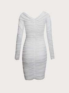Detail of white long sleeve dress featuring back deep V-neck and ruched sequin fabric