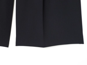 Détail de la texture du tissu noir et des surpiqûres contrastées sur ce short long