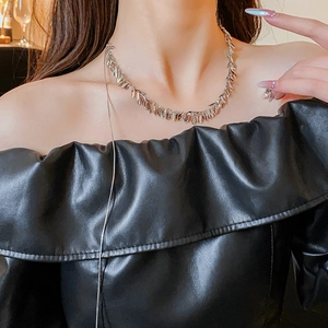 Detail shot of silver leaf tassel choker necklace on model showing minimalist style