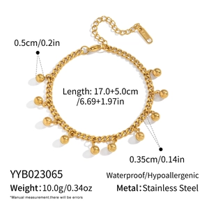 Detail view of 18K gold plated stainless steel Cuban link bracelet with bead charms