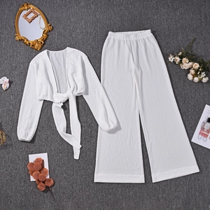 Mise à plat d'un ensemble blanc texturé haut court à manches longues et pantalon large