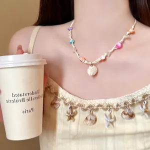 Detail of beaded shell pendant necklace with colorful stones on white braided rope