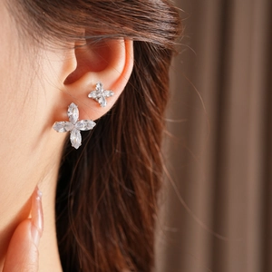 Détail de boucles d'oreilles fleurs en zircon portées par un mannequin sous lumière douce