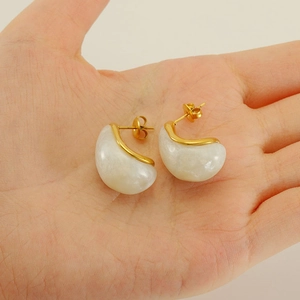 Detailed close-up of water drop earrings in gold-plated stainless steel and white resin