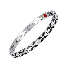 Detail of silver titanium magnetic therapy bracelet with black clover pattern and inlay