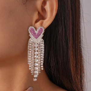 Boucles d'oreilles cœur à pompon rose et strass pour un look féminin et tendance