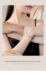 Dettaglio di bracciali per coppia in argento 925 con spine e rose su braccia