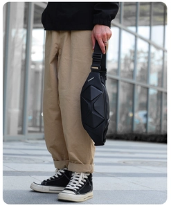Macro view of geometric hard shell texture and urban techwear design on black crossbody bag