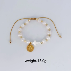 Vue détaillée du bracelet religieux en perles avec croix et médaille de Saint Benoît.