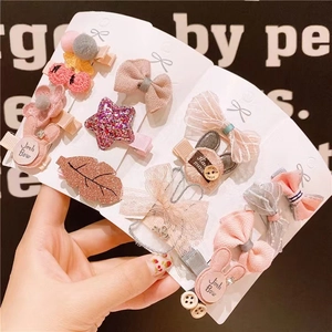 12-piece set of pink and beige fabric bow hair clips for girls on a display card
