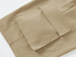 Detail shot of the khaki cargo pockets with reinforced stitching on men's beach shorts