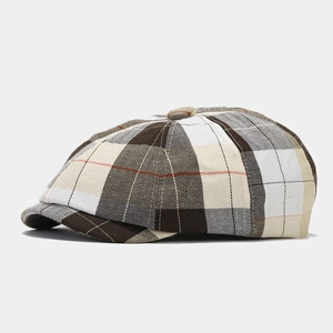 Dettaglio del berretto newsboy vintage con motivo a quadri marrone e beige e trama