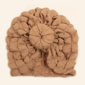 Detailed view of coffee brown donut knot on soft pleated cotton baby turban hat