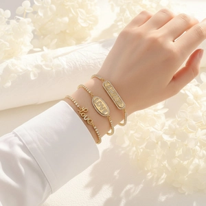 Detailed view of three gold adjustable bracelets featuring crystal-encrusted LOVE and AMOUR lettering