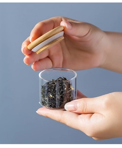 Detail of portable glass tea canister with wooden lid and airtight silicone seal