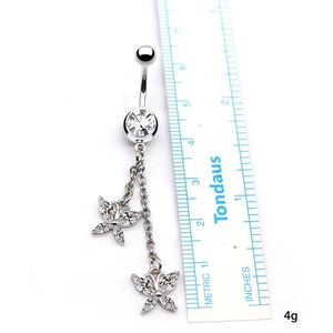 Détail du piercing de nombril argenté avec pendentifs papillon et cristaux brillants