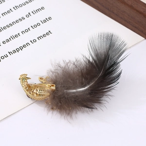 Detailed back view of a peacock brooch showing gold hollow craft and grey feather