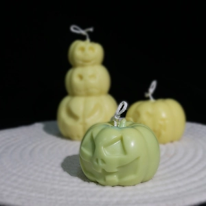 Macro detail of Halloween pumpkin candles with funny faces in green and yellow