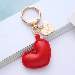 Close-up of red leather heart keychain with golden Love tag and lobster clasp detail
