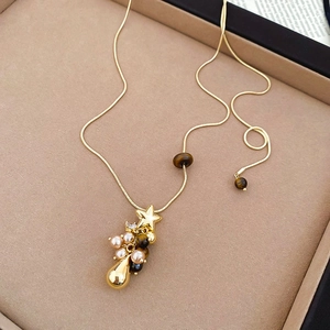 Détail du collier étoile dorée perles et pierres œil de tigre dans un coffret