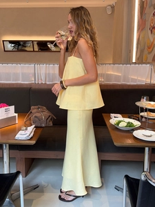 Detail of light yellow two-piece cotton linen set featuring thin strap top and maxi skirt