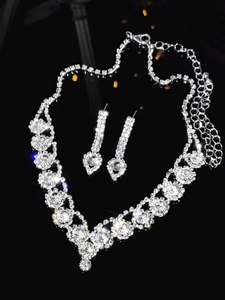 Macro shot of silver bridal jewelry set with sparkling zircons on black surface