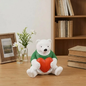 Polar bear holding a red heart resin statue on a wooden desk with home decor