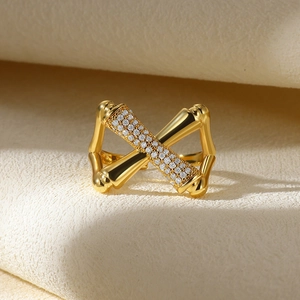 Detailed macro view of a gold-plated crossover ring with pavé zircons and bamboo texture