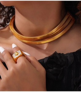 Detail of layered gold choker necklace and lion head ring with sparkling crystals