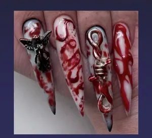 Detail of 3D stiletto press on nails with realistic blood splatter and silver angel charms