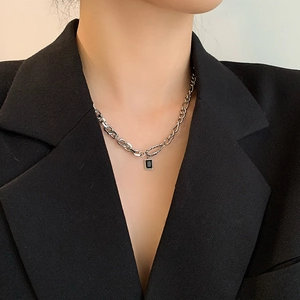 Silver geometric chain necklace featuring a black rectangular gemstone pendant on a model