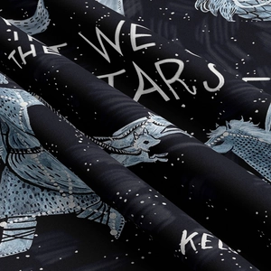 Detailed view of dark tapestry fabric with stars and unicorn print and The Stars text