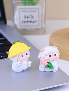 Close-up of two mini resin sheep figurines with straw hat and pink tulip flower decor