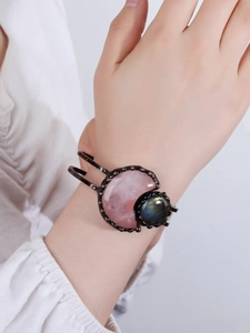Close-up of vintage bronze cuff bracelet with pink moonstone and blue labradorite on wrist