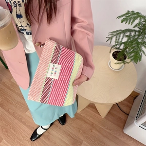 Detailed view of woven fabric texture on a striped colorful cosmetic storage bag