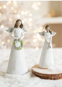 Close-up of resin angel figurines with silver wings and wood-like texture for Xmas decor