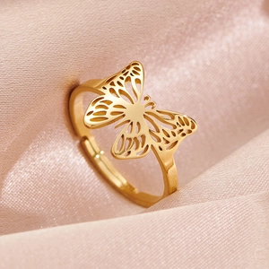 Elegant gold butterfly open ring with hollow design on pink silk fabric background