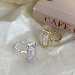 Detail view of gold and silver S925 sterling silver rings with rectangle zircon on white paper