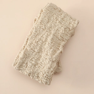 Detail of soft cream oversized bow headband with elastic ribbed knit fabric texture
