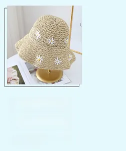 Close-up of beige straw hat with daisy floral patches and UPF 50+ sun protection feature