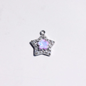 Detailed view of a silver star pendant with a pink opal flower and sparkling crystals