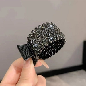 Detailed close-up of a black hair claw clip featuring shimmering dark rhinestones