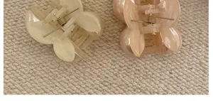 Detailed macro view of resin cherry hair clips in cream and pink with gold metal springs