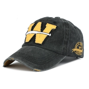 Detail of vintage washed cotton baseball cap with yellow W embroidery and side patch