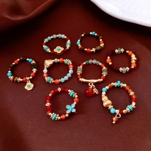 Vintage style set of eight tiger eye and agate beaded rings with gold metal accents