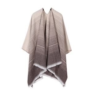 Detail of gradient beige to brown knit shawl with striped pattern and fringe tassels
