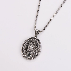 Macro detail of silver oval pendant with embossed Jesus portrait and thorn texture
