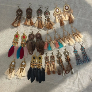 Flat lay of bohemian tassel earrings with feathers, alloy metal and colorful beads