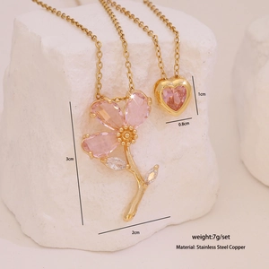 Détail des pendentifs fleur et cœur en zircon rose sur colliers en acier inoxydable