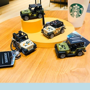 Detailed view of 3D camouflage jeep keychains with roof racks on wooden display